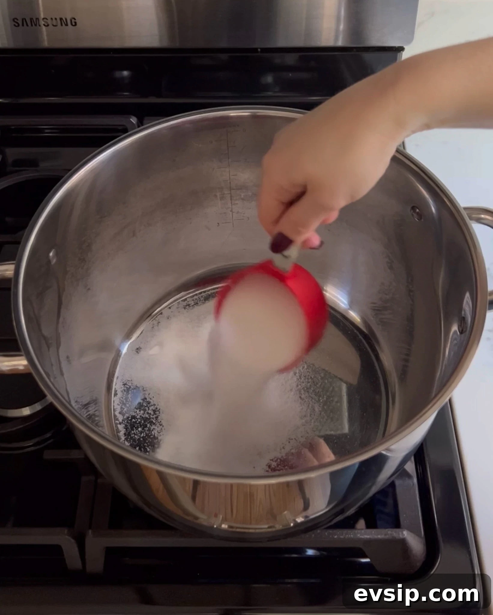 Adding sugar to a large pot.