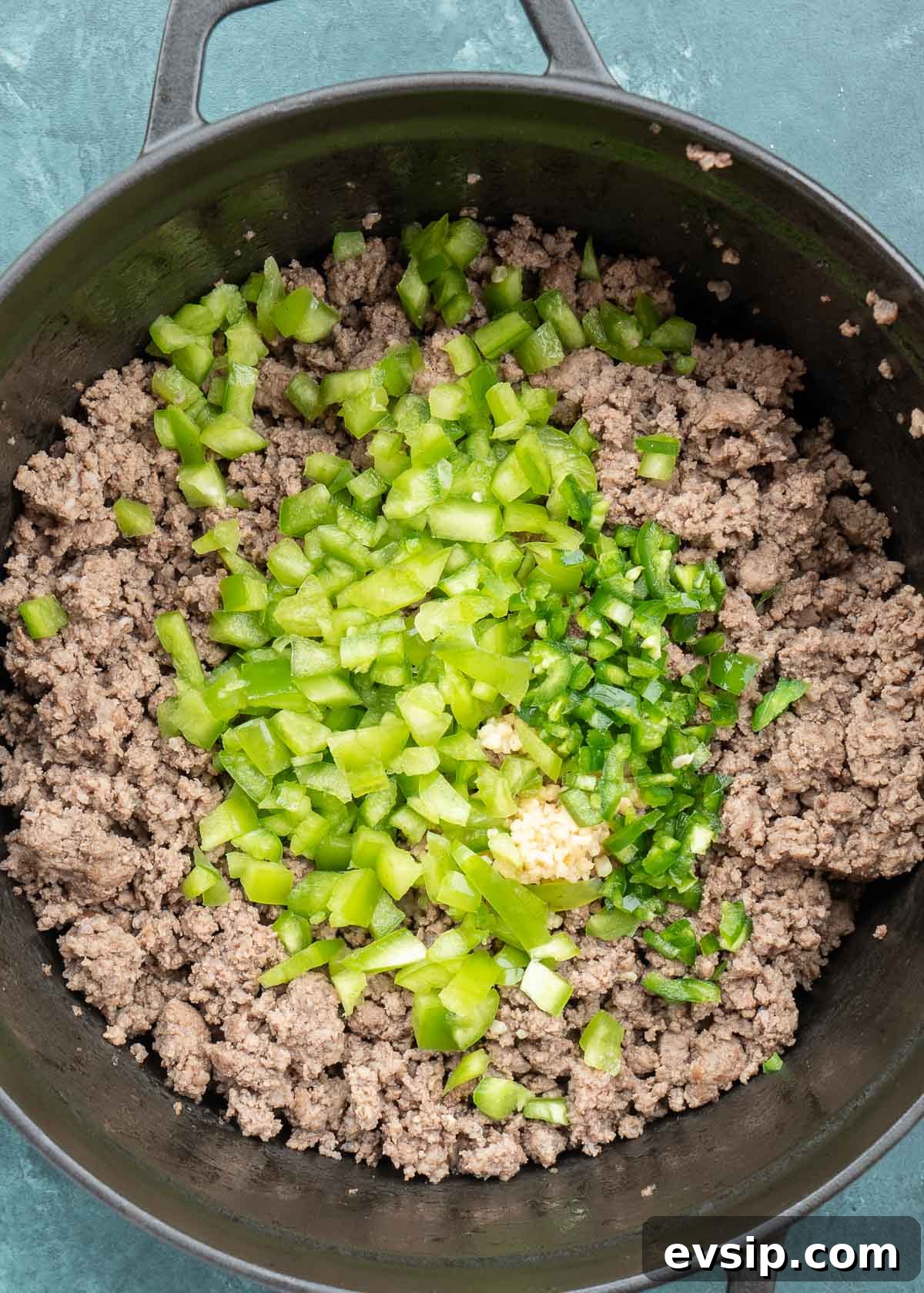ground beef, peppers and garlic in dutch oven