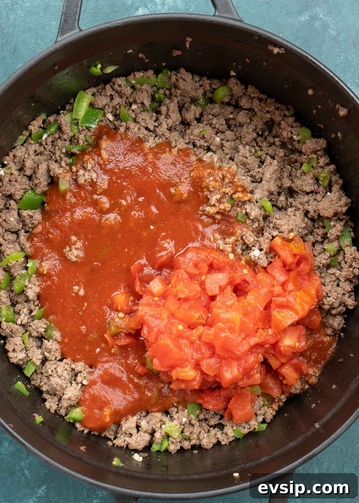 ground beef, peppers, tomato sauce and canned tomatoes in dutch oven