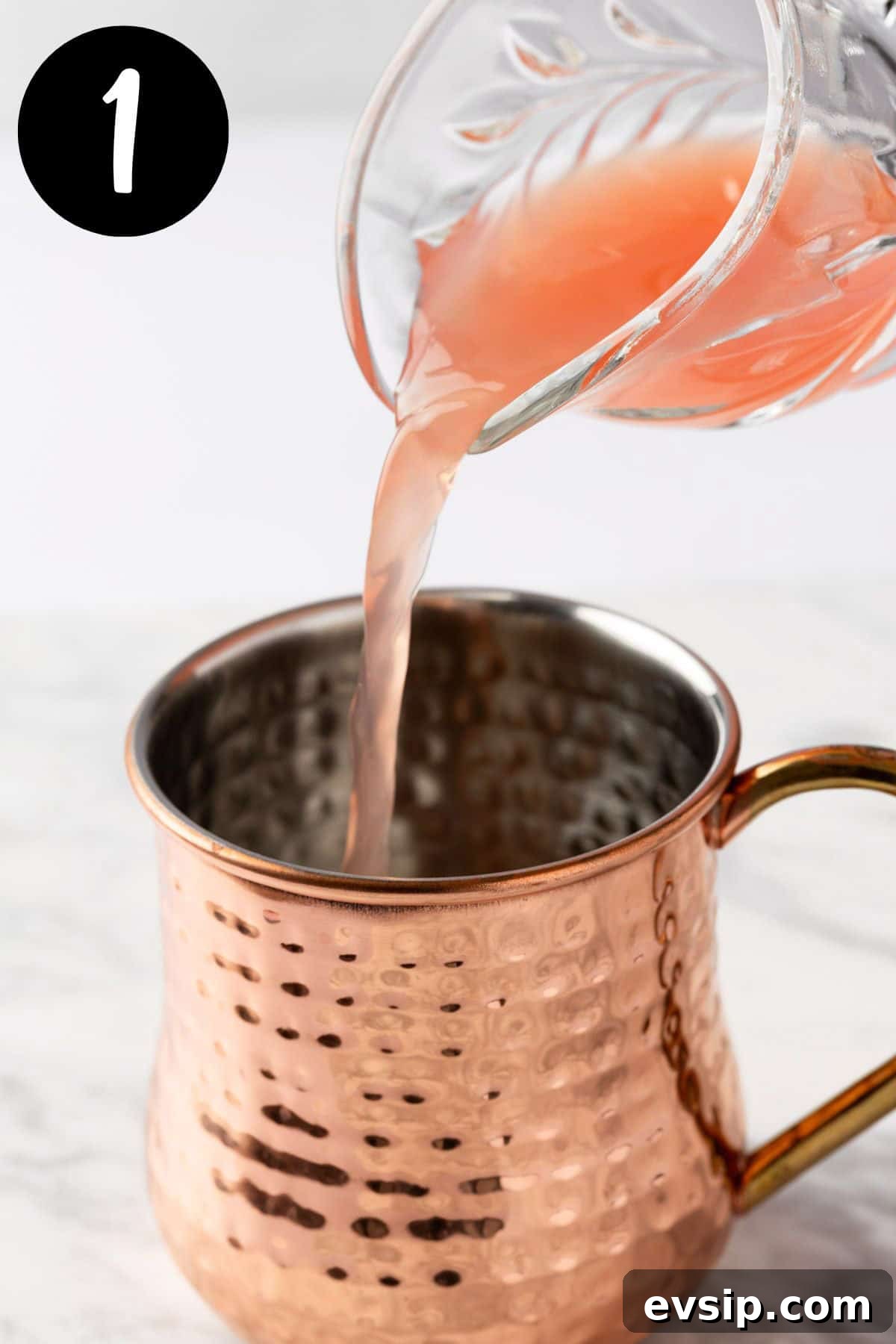 Pouring the grapefruit juice into a copper mug.