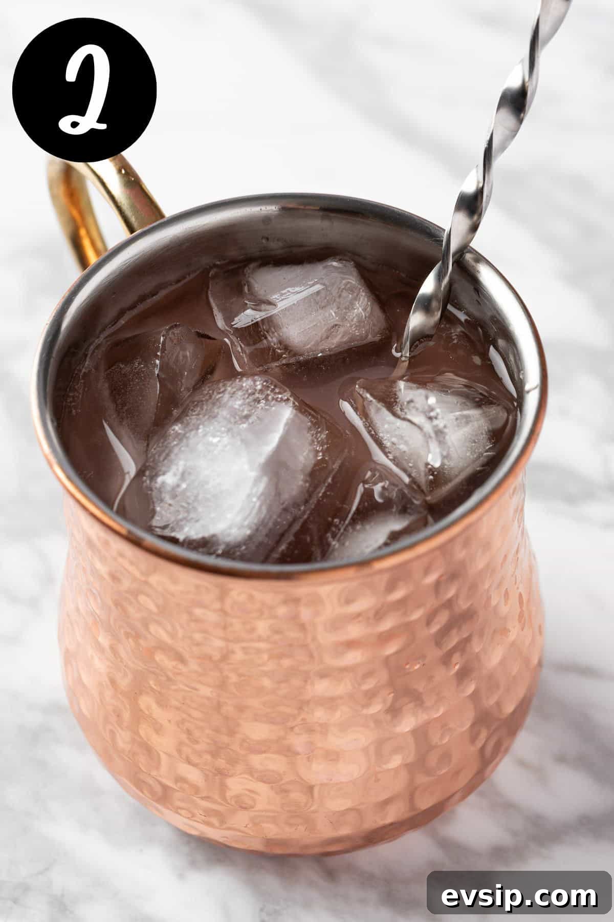 Stirring in the ice and ginger beer.
