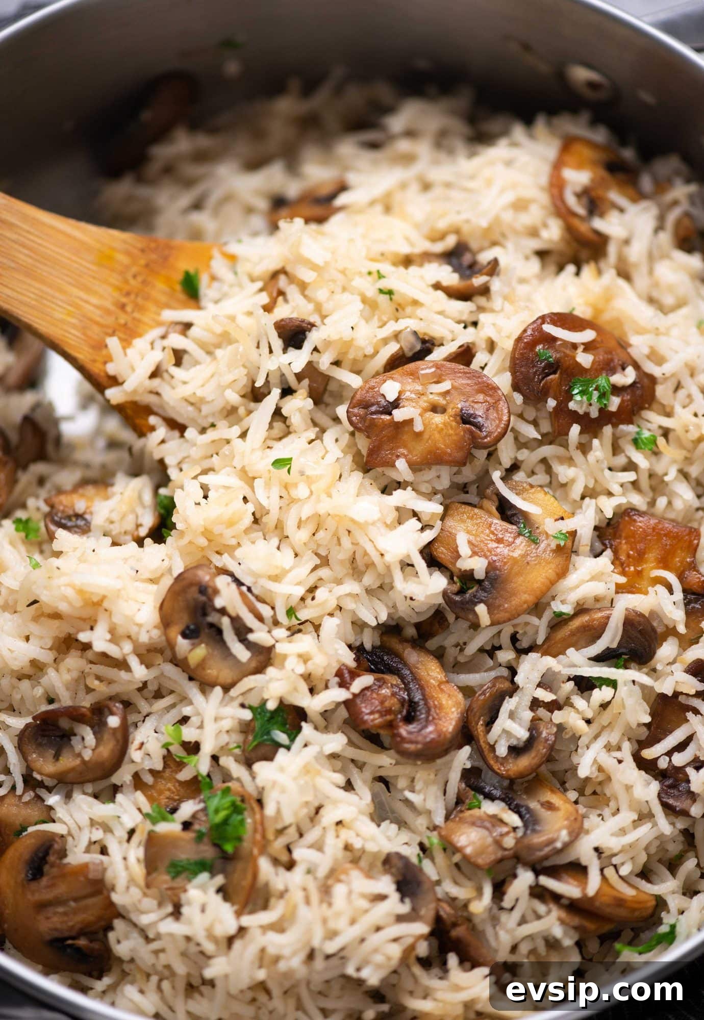 Close-up picture of Mushroom rice garnished with fresh parsley and browned mushroom.