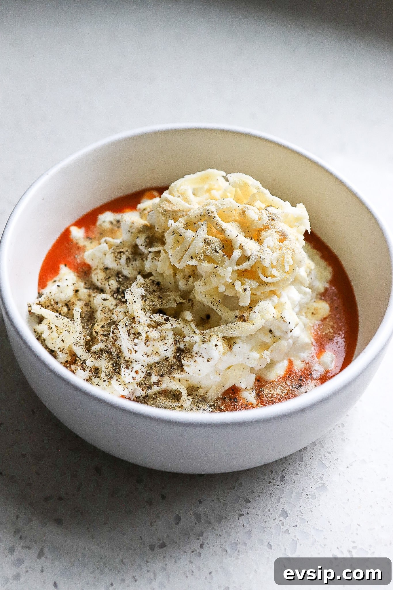 Buffalo Chicken Cottage Cheese Bowl for High-Protein Meals 5 Side angle of a buffalo chicken bowl recipe with mozzarella cheese.