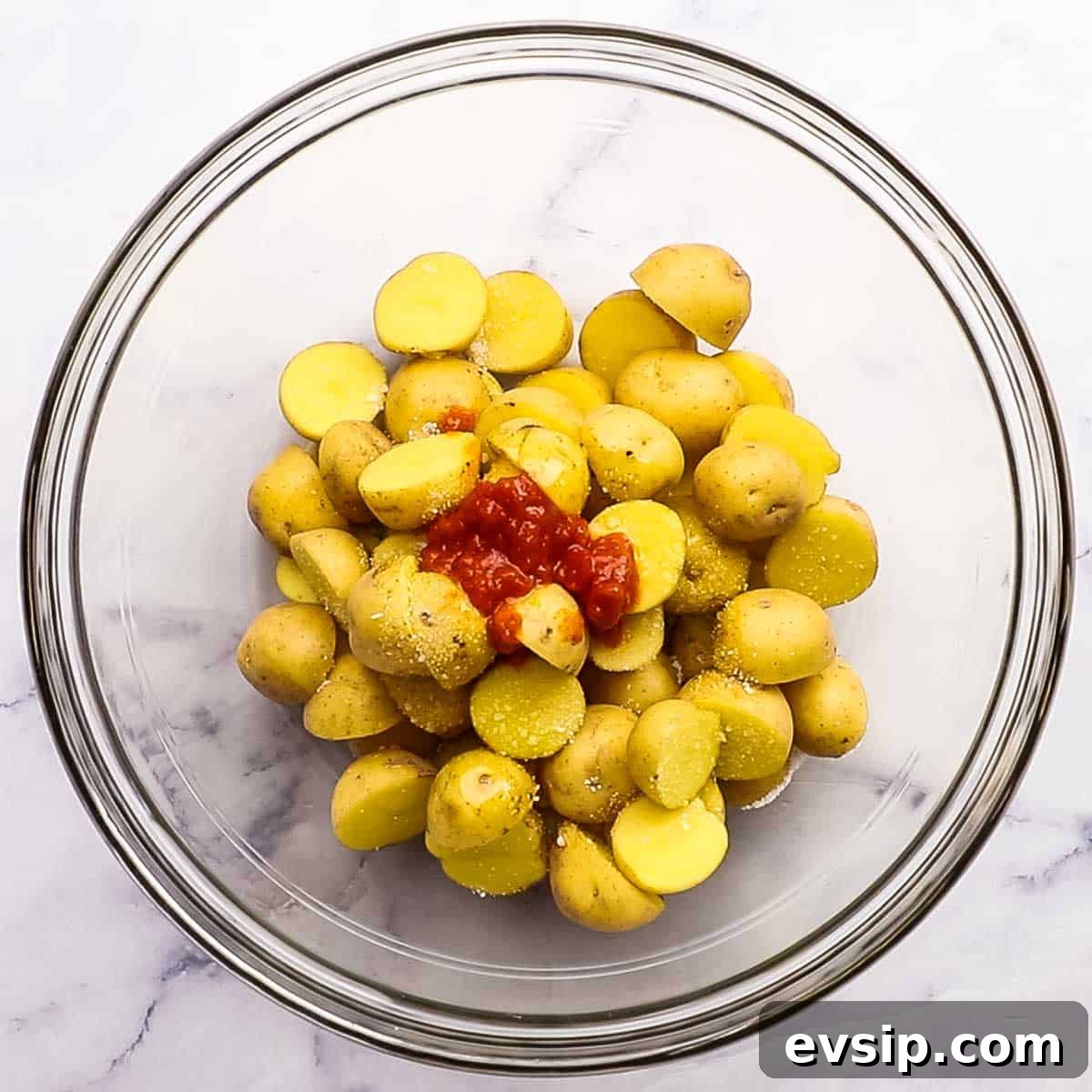 baby potatoes in a bowl with salt, harissa paste, and olive oil