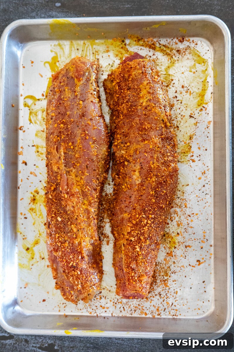 two pork tenderloins rubbed with seasoning.