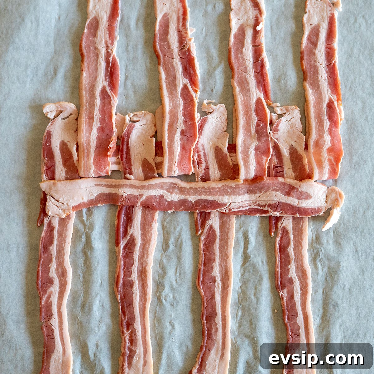 even rows of bacon folded back with slice of bacon on top.