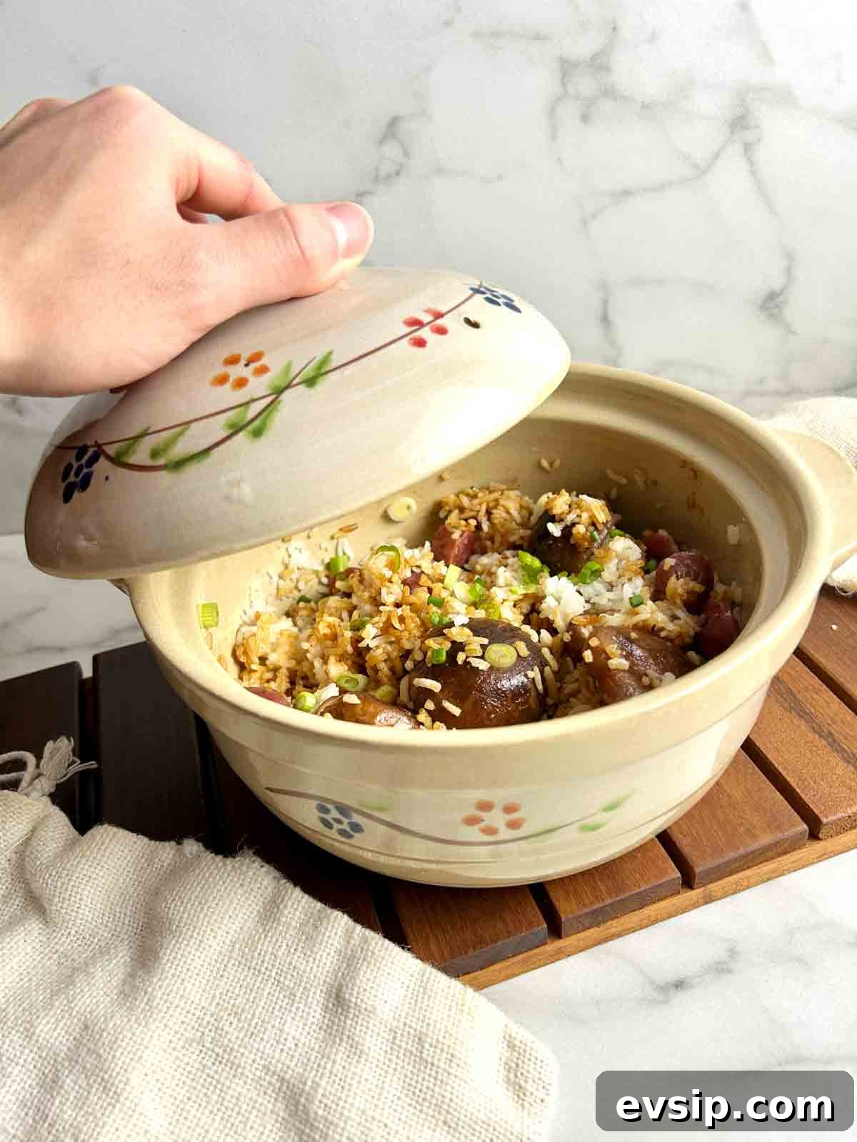 hand lifting lid off of clay pot