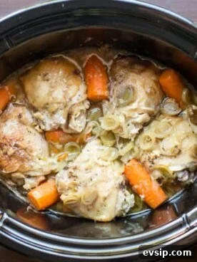 chicken thighs in sauce in a slow cooker with leeks and carrots.