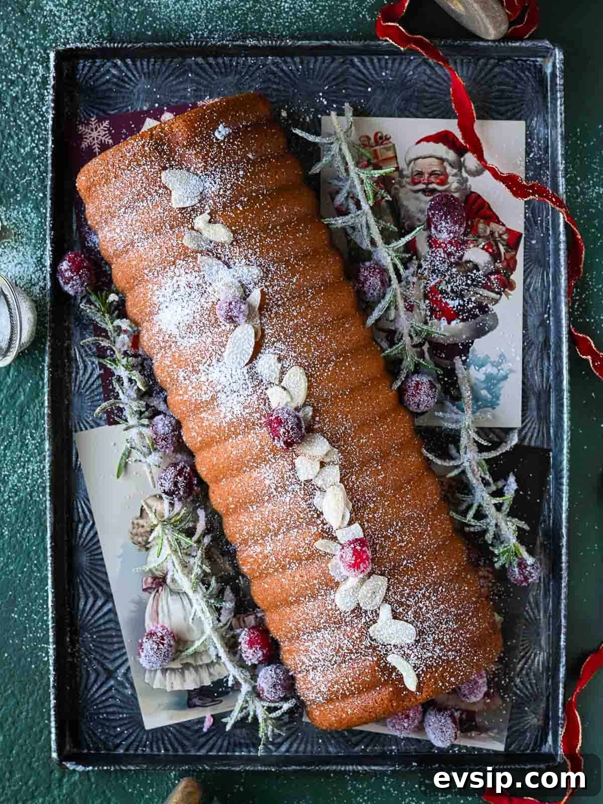 Overhead of an almond cake on a silver tray.