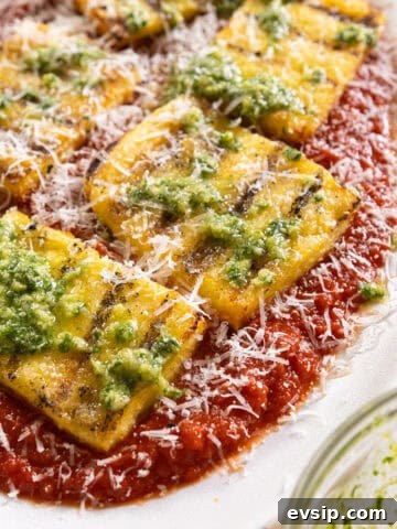 Grilled polenta on marinara topped with pesto and parmigiano.