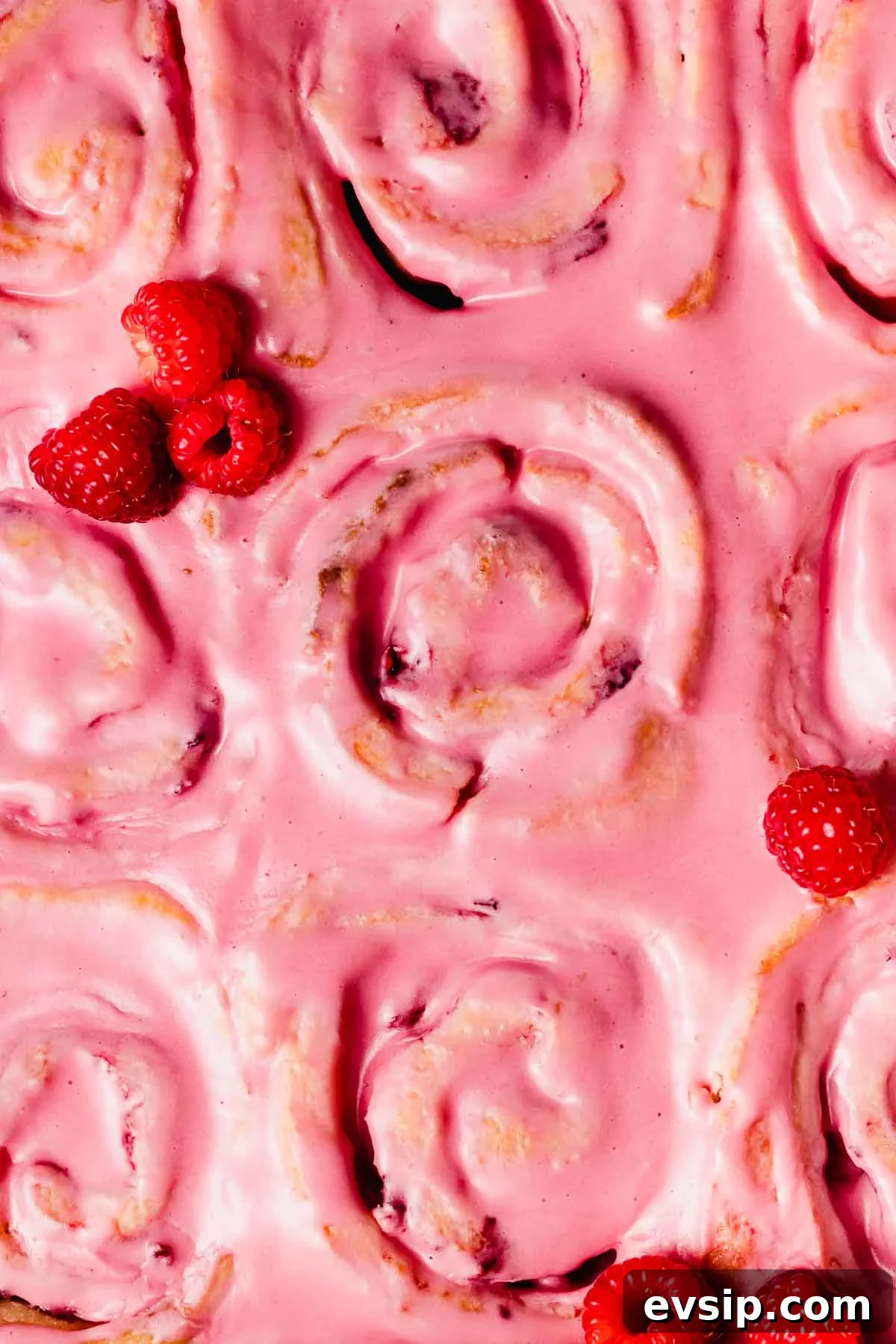 Gooey Raspberry Rolls Recipe: Soft, Homemade Pastry 6 closeup of the top of pink glazed raspberry rolls