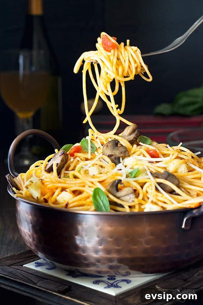 Caramelized Cauliflower & Mushroom Spaghetti Recipe for Dinner 2 A fork with spaghetti over a bowl with food.