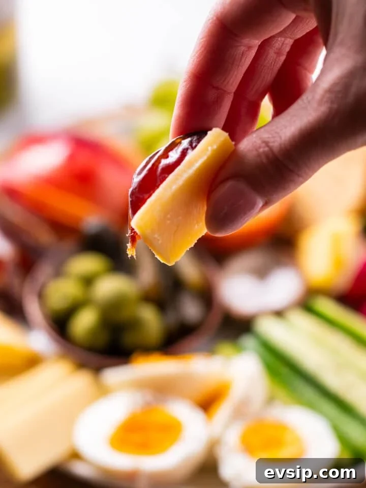 hand holding a date and piece of cheese
