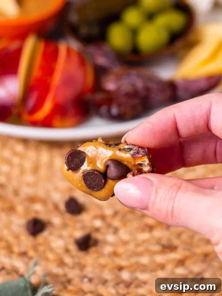 hand holding a date with peanut butter and chocolate chips