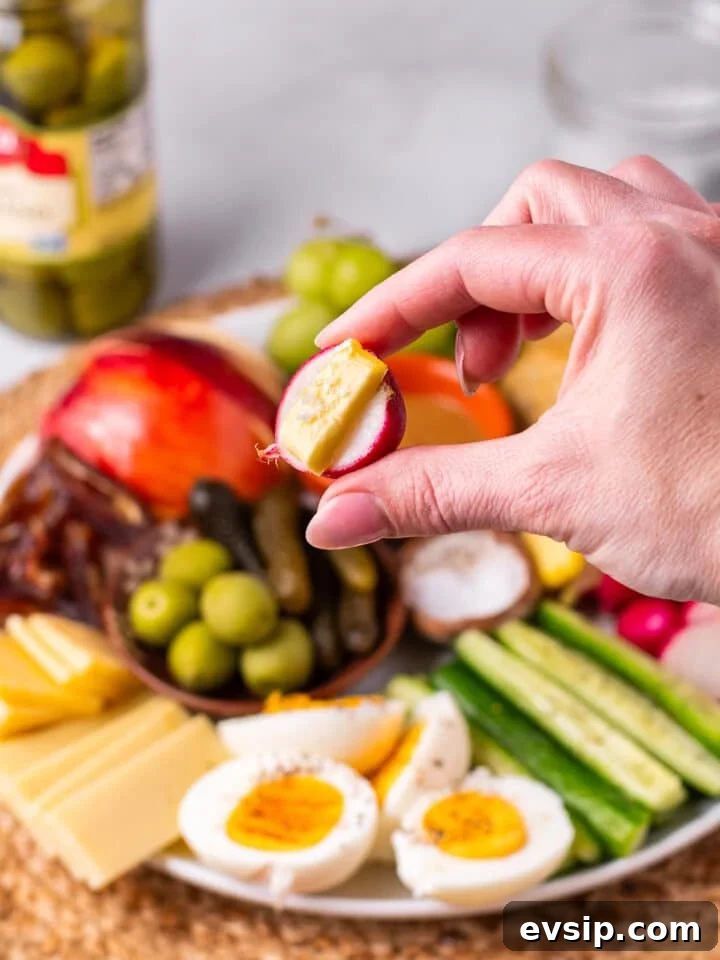 hand holding a radish with pat of butter and flaky sea salt