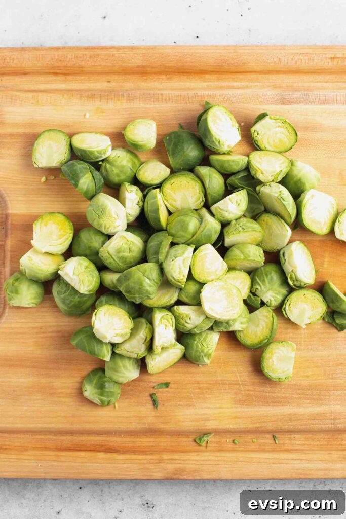 Roasted Brussels Sprouts with Goat Cheese and Honey Glaze 5 Sliced Brussels sprouts on a wood cutting board.
