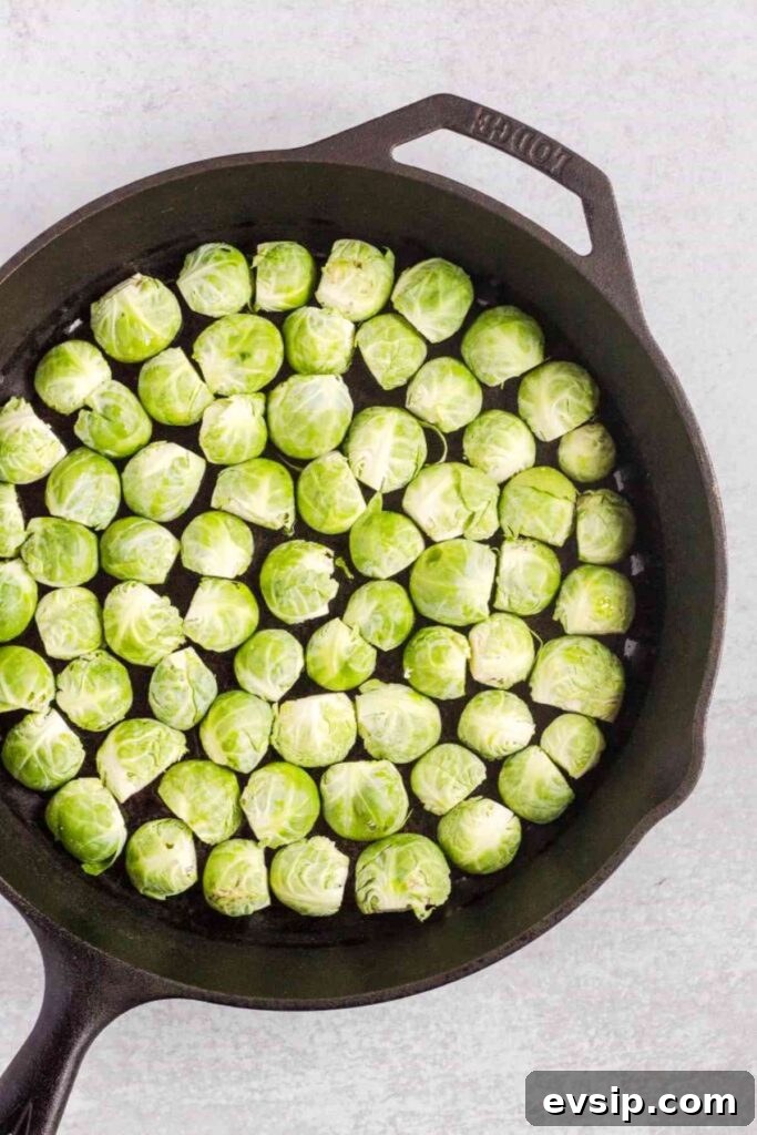 Roasted Brussels Sprouts with Goat Cheese and Honey Glaze 6 Sliced Brussels sprouts cut side down in a cast iron skillet.