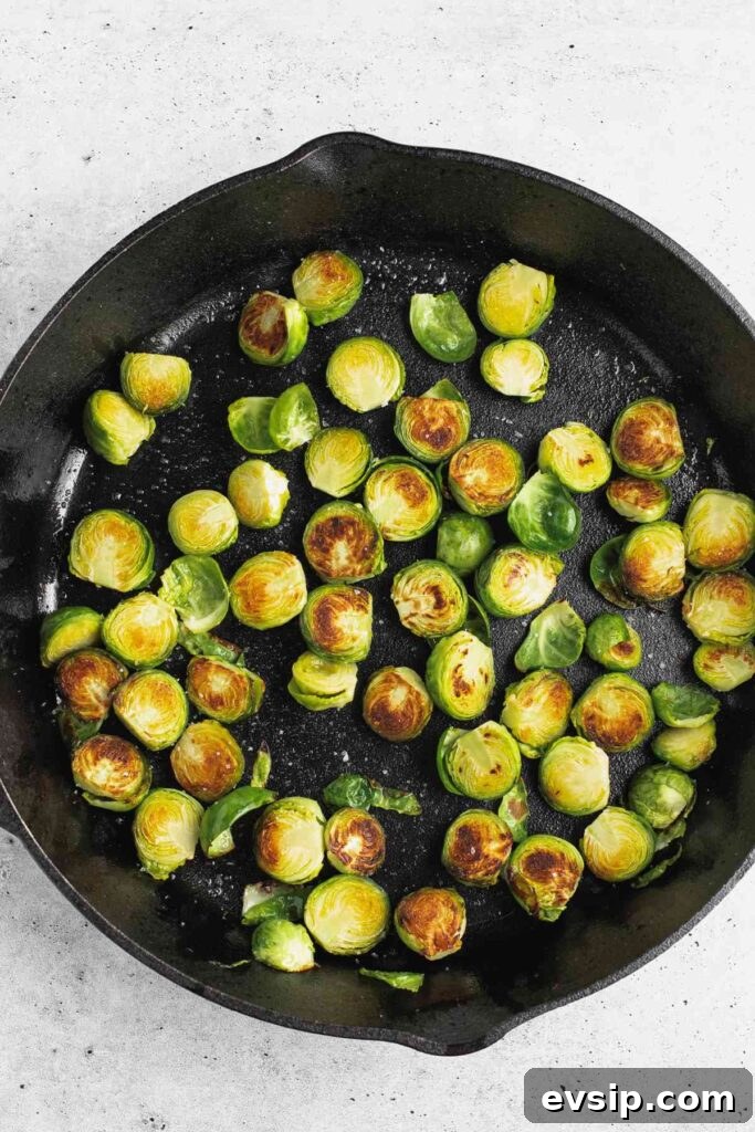 Roasted Brussels Sprouts with Goat Cheese and Honey Glaze 7 Sliced and roasted Brussels sprouts in a cast iron skillet.