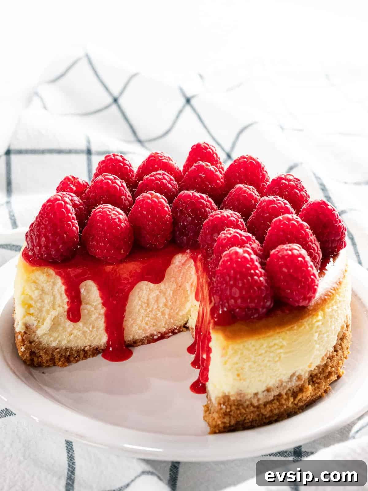 Silky Raspberry Cheesecake Recipe with Fresh Berry Glaze 11 Raspberry cheesecake with fresh raspberry topping and sauce.