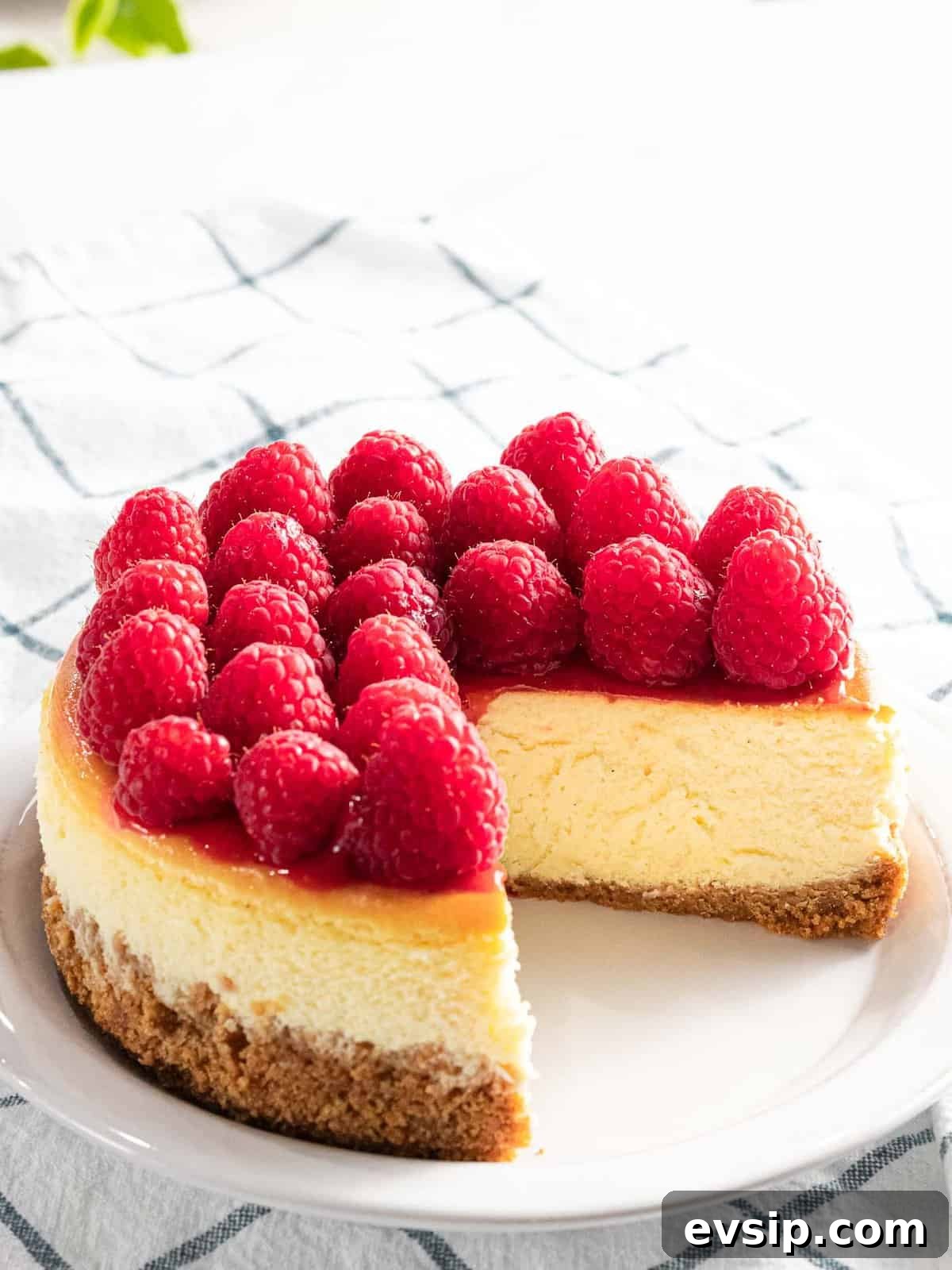 Silky Raspberry Cheesecake Recipe with Fresh Berry Glaze 3 Raspberry cheesecake with fresh raspberry topping.