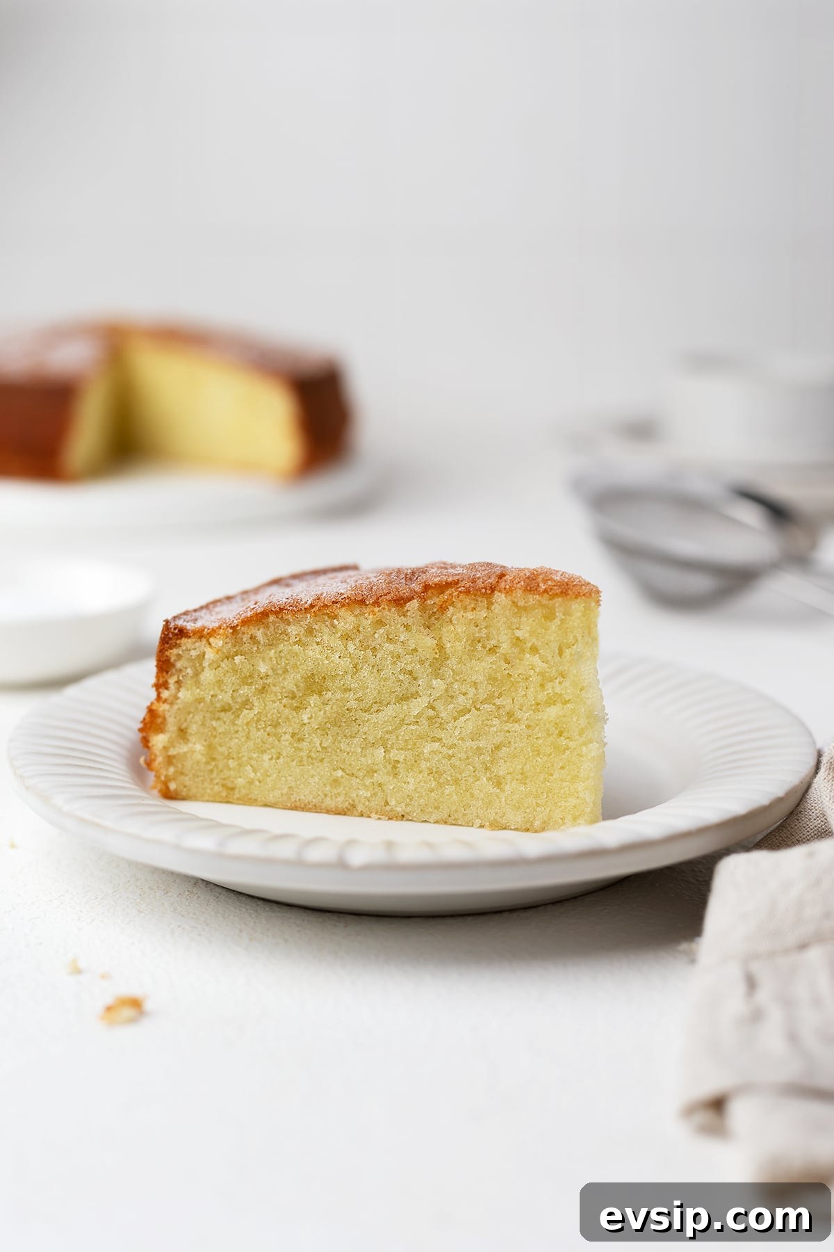 A single slice of the oil sponge cake on a dessert plate.