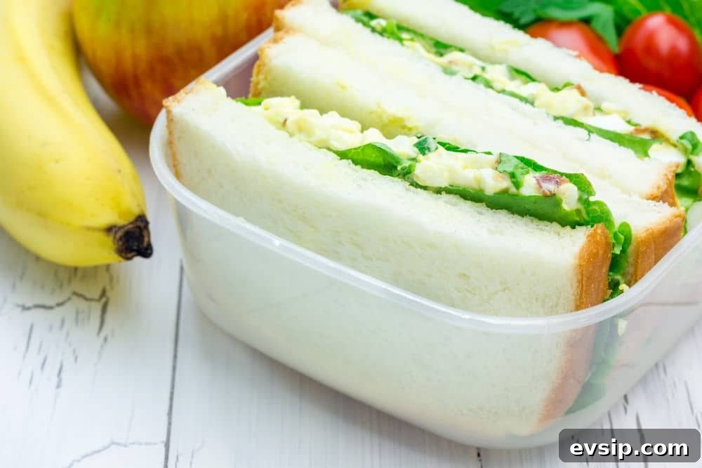 Lunch box with egg salad sandwiches, apple and banana Lunch box with egg salad sandwiches, apple and banana
