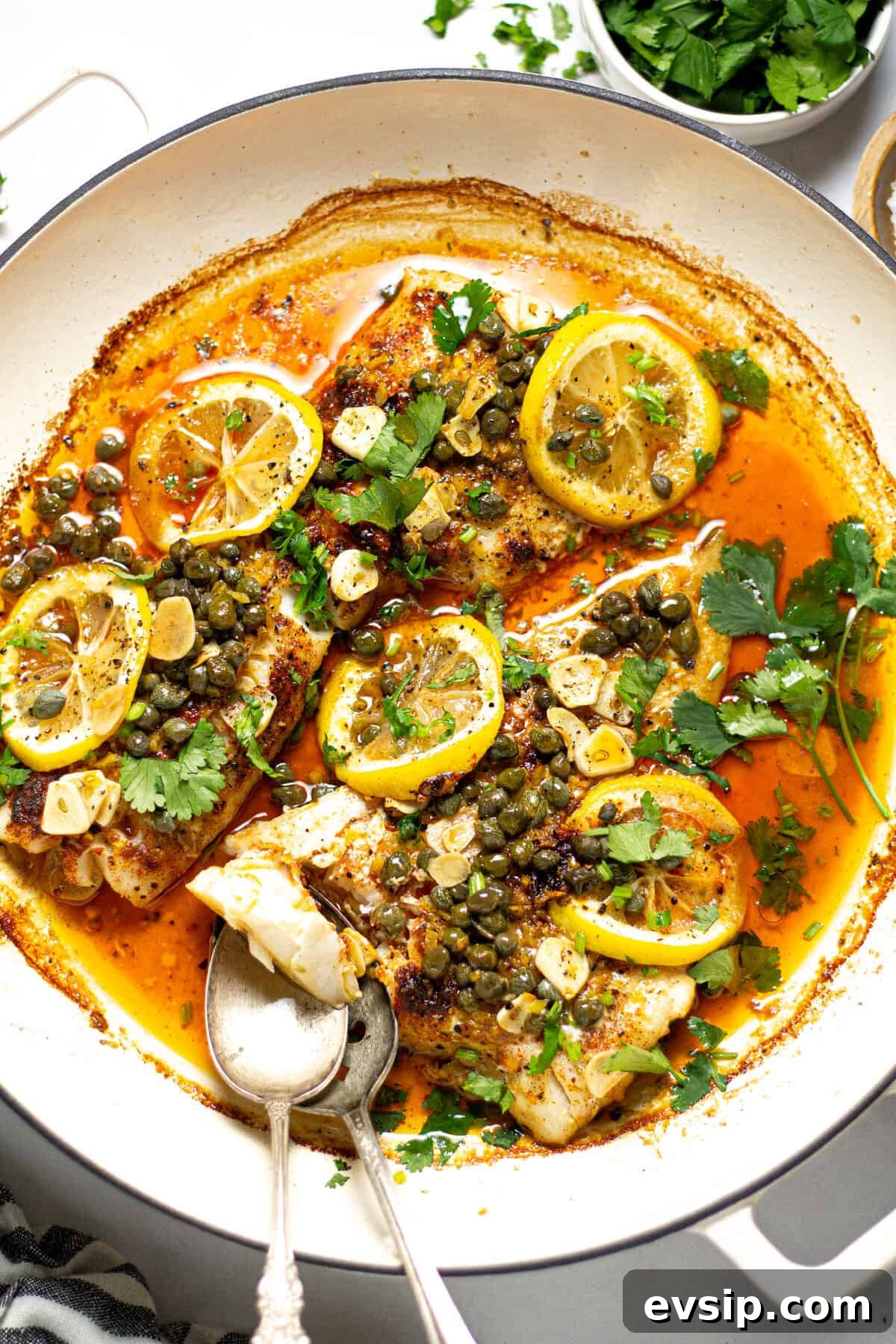 Overhead shot of a pot filled with baked Mediterranean cod garnished with fresh cilantro