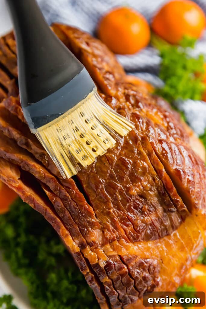 Brushing juices onto a spiral ham.