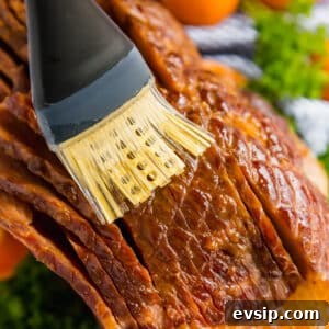 Brushing juices onto a spiral ham.