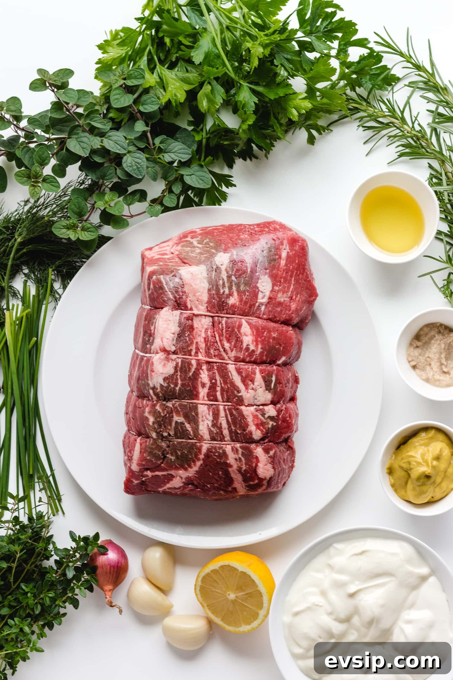 Overhead photo on a white background of all the ingredients needed to make Herb Mustard Crusted Roast Beef with Creamy Herb Sauce.