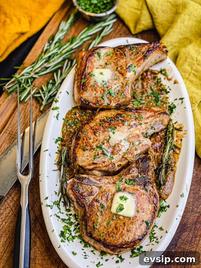 Pan-Seared Pork Chops with Rustic Sun-Dried Tomato Sauce 2 pan seared pork chops on a platter with rosemary and a knife in the background