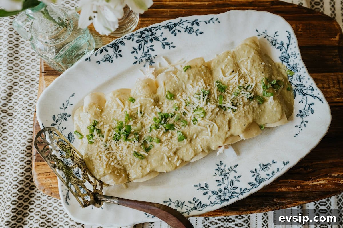 Authentic Green Enchiladas (Enchiladas Verdes) Recipe for Dinner 12 Flat lay of a serving platter filled with rolled enchiladas verdes, topped with melted white cheese and fresh cilantro, ready to serve.