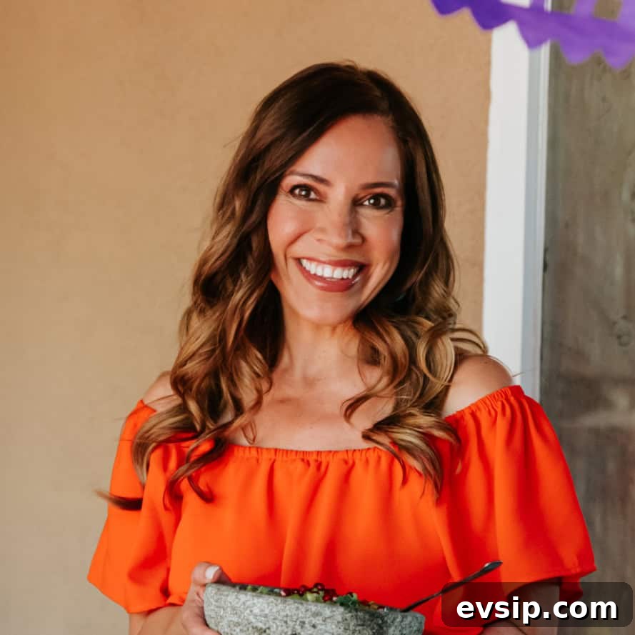 Authentic Green Enchiladas (Enchiladas Verdes) Recipe for Dinner 4 Yvette Marquez muy bueno Mexican food blogger in an orange dress holding a molcajete.