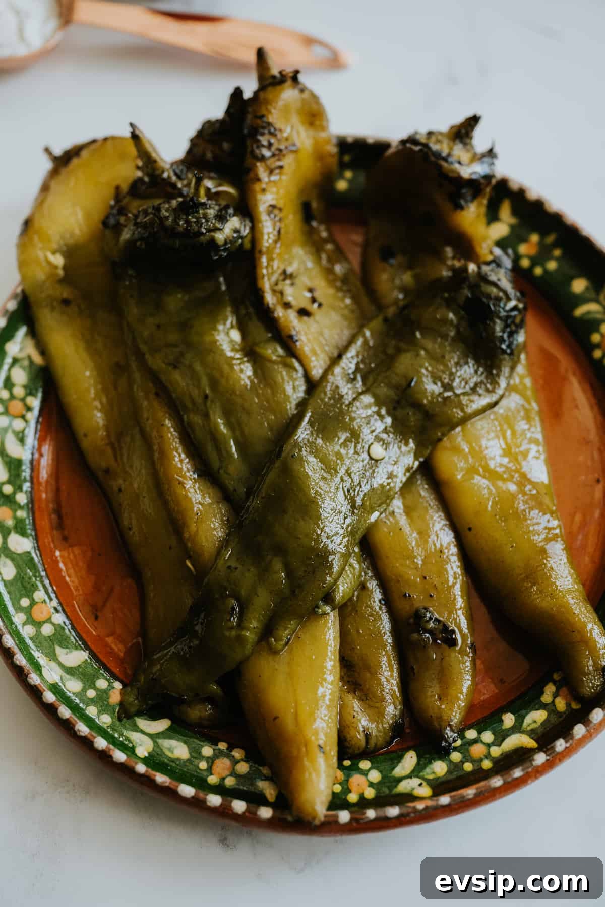Authentic Green Enchiladas (Enchiladas Verdes) Recipe for Dinner 6 Close-up of a plate filled with roasted and peeled Hatch green chiles, ready to be blended into creamy enchilada sauce.