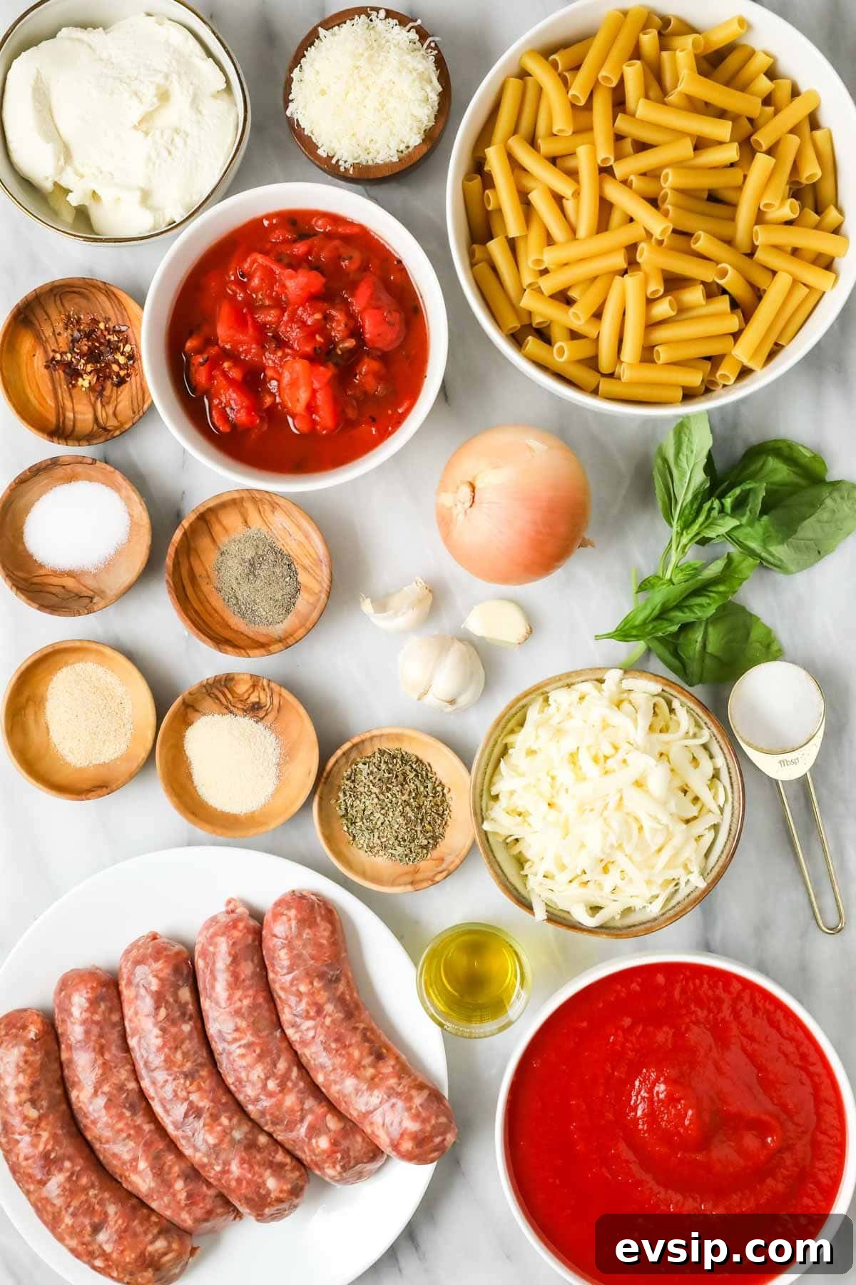 Classic Baked Ziti with Melty Cheese and Italian Sausage 4 Overhead view of ingredients including sausage, tomato sauce, ziti noodles, and more.