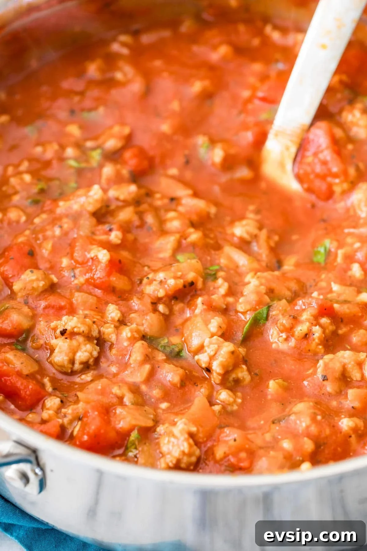 Classic Baked Ziti with Melty Cheese and Italian Sausage 6 Close-up view of a pot of pasta sauce made with sausage and fresh basil.