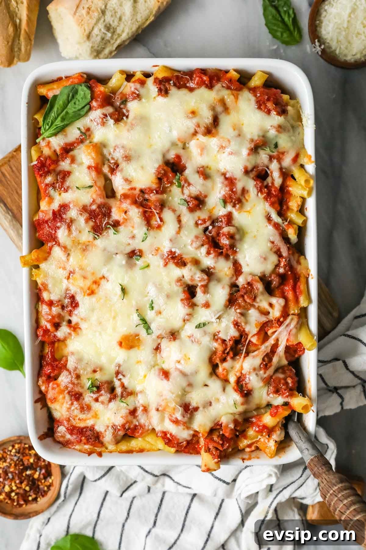 Classic Baked Ziti with Melty Cheese and Italian Sausage 8 Overhead view of a baked pasta dish topped with shredded mozzarella.