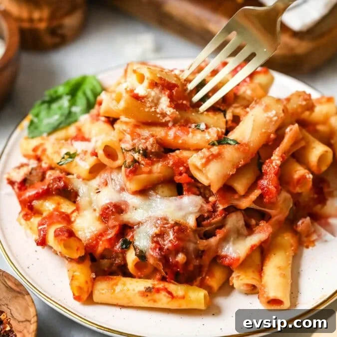 Classic Baked Ziti with Melty Cheese and Italian Sausage 10 Plate with a serving of baked ziti.
