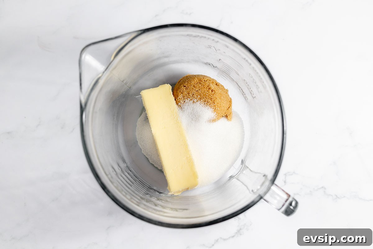 Butter, brown, and white sugar in a mixing bowl.