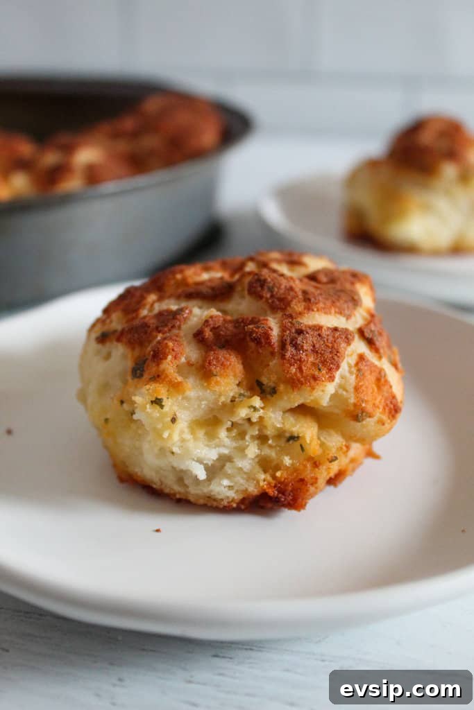 Gluten-Free Dairy-Free Parmesan Pull-Apart Rolls 4 gluten free parmesan roll on a white plate.