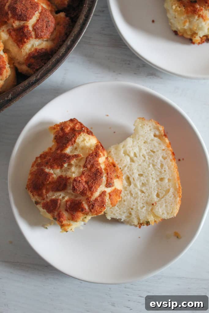 Gluten-Free Dairy-Free Parmesan Pull-Apart Rolls 8 gluten free parmesan roll split in half on a white plate.