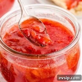 Cinnamon French Toast Roll-Ups with Maple Dipping Sauce 15 close up shot of a jar of Strawberry Freezer Jam with a spoonful of strawberry jam