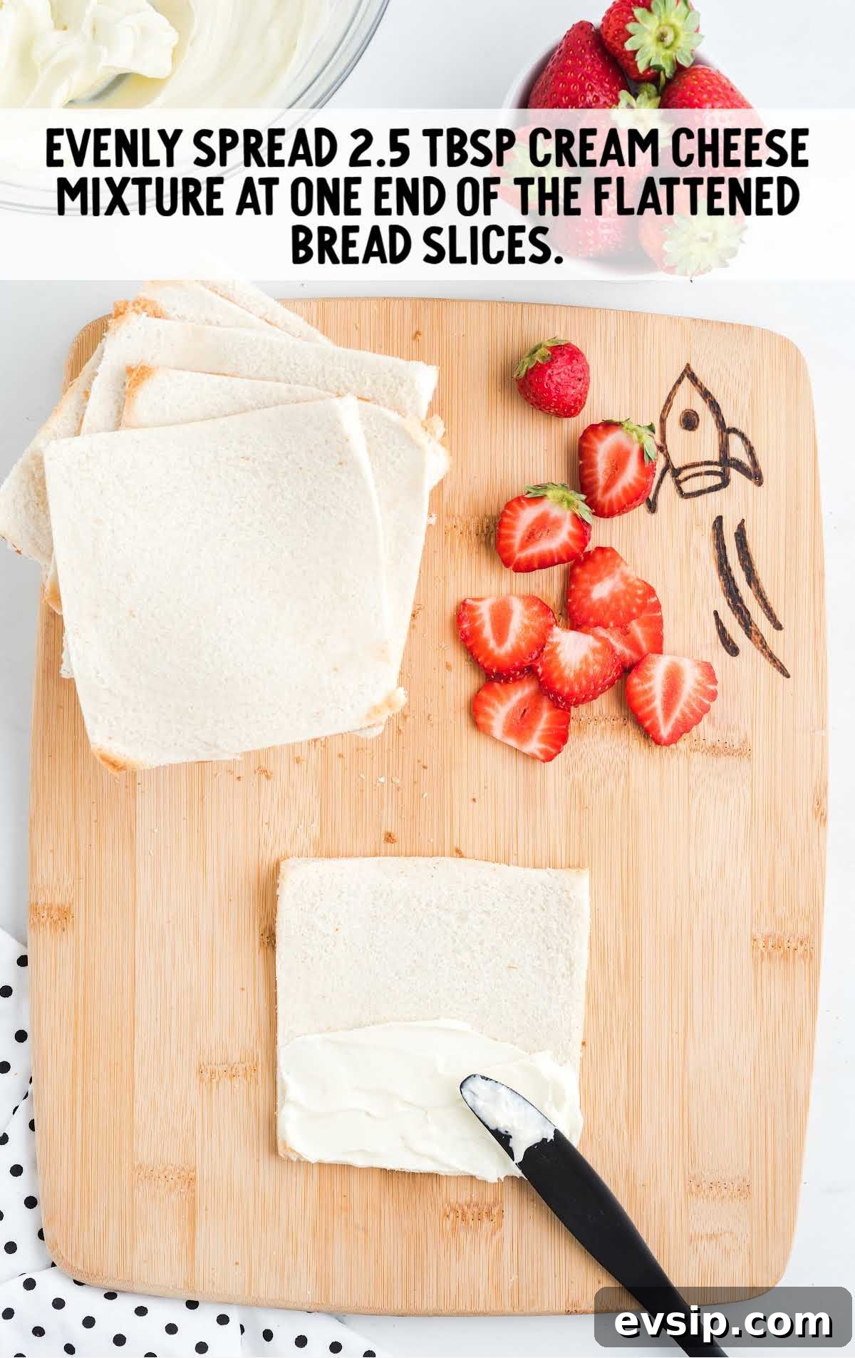 Cinnamon French Toast Roll-Ups with Maple Dipping Sauce 9 cream cheese mixture being spread onto bread slices on a wooden board