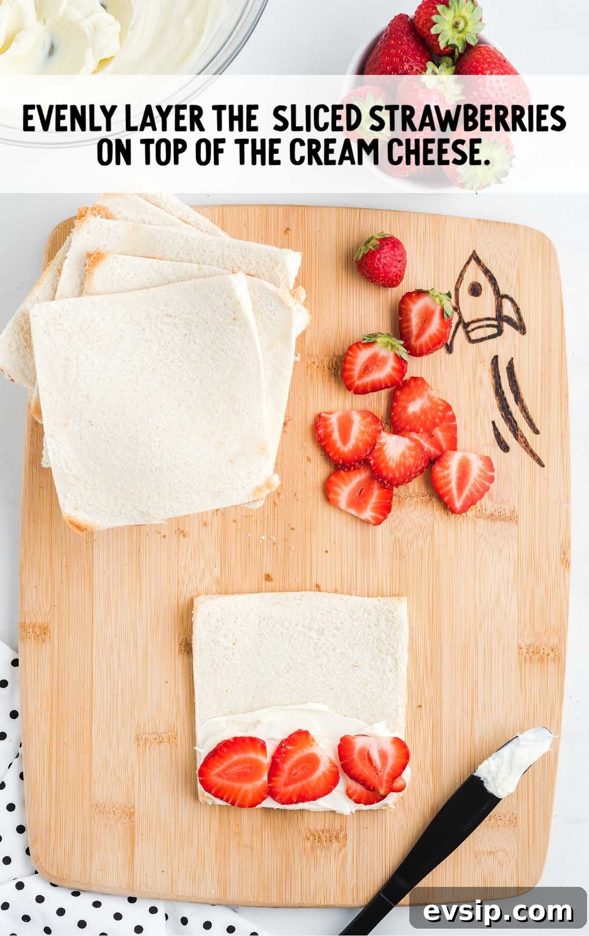 Cinnamon French Toast Roll-Ups with Maple Dipping Sauce 10 slices of strawberries being layered on top of the cream cheese mixture on the bread