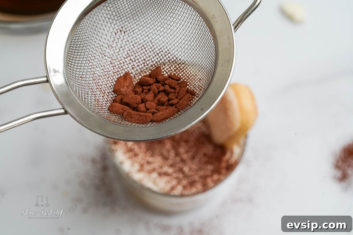 Individual Egg-Free Tiramisu Cups: Creamy No-Bake Dessert 9 dusting the top of tirimisu with cocoa powder