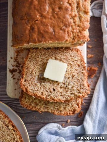 A pat of butter is on a slice of the banana bread with pancake mix.