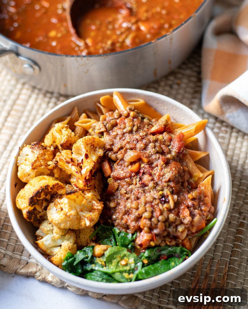 French Green Lentil Bolognese Recipe for Hearty Weeknight Meals 4 a serving dish with vegan green lentil bolognese next to a large saucepan with the pasta sauce ready to serve.
