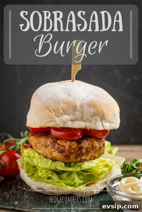 Spicy Sobrasada Burger Recipe with Crispy Onion and Manchego 2 A tall sobrasada burger layered with lettuce, tomato and a wooden skewer holding it all together