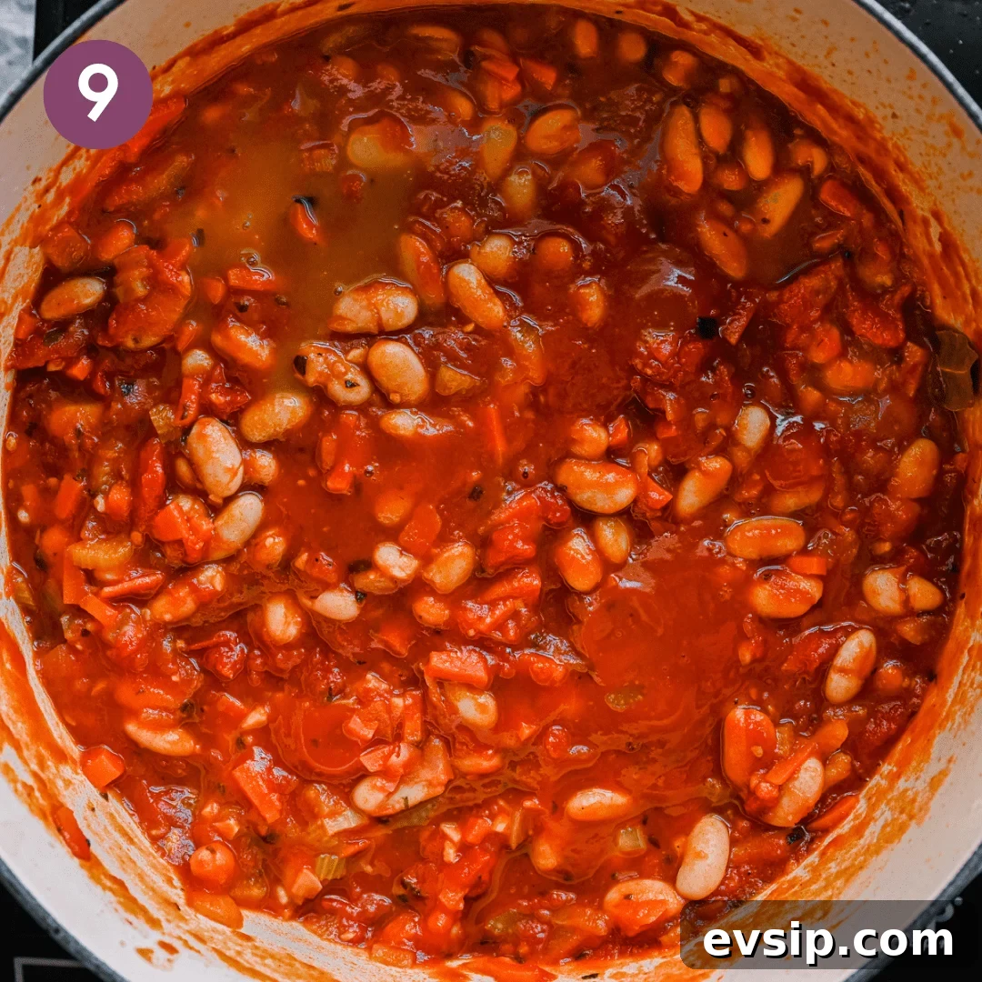 thick and rich tuscan stewed beans with tomatoes in a dutch oven.