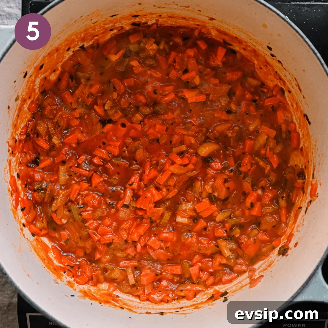 white wine deglazing a dutch oven with tomato paste, onions, carrots, and celery for an italian stew. 